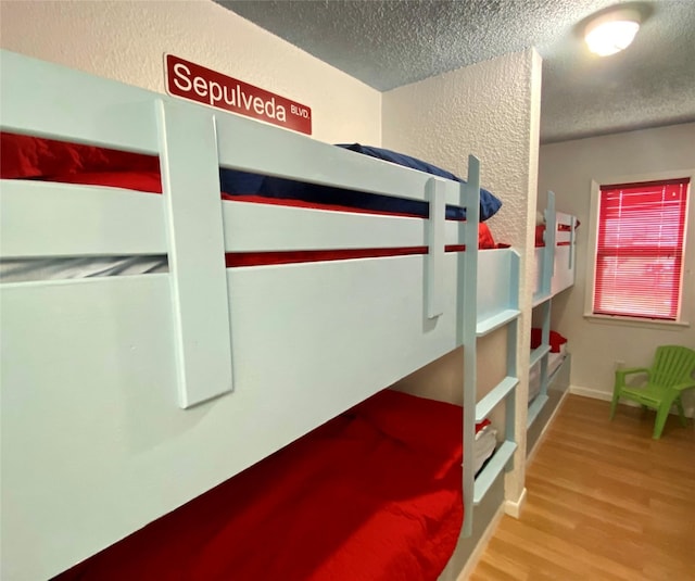 bedroom with wood-type flooring and a textured ceiling