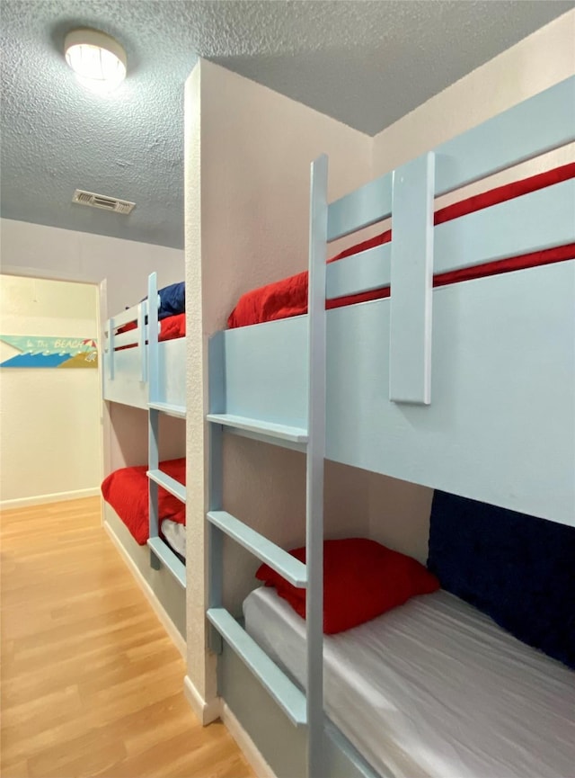 bedroom featuring a textured ceiling and wood-type flooring