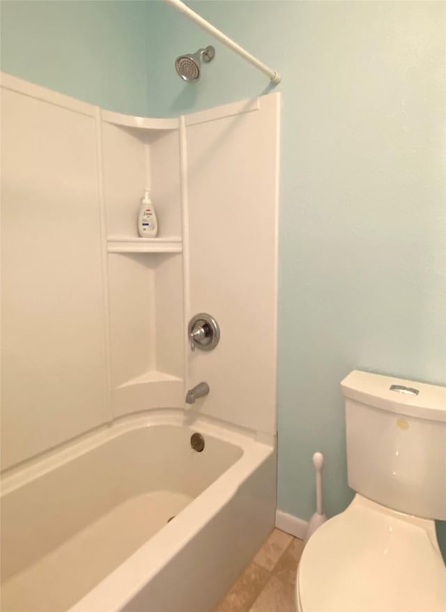 bathroom with toilet, tile patterned flooring, and shower / washtub combination