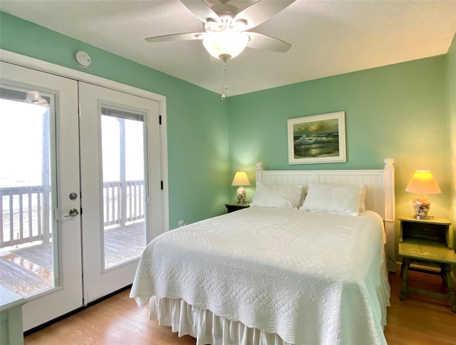 bedroom featuring ceiling fan, french doors, access to outside, and light hardwood / wood-style floors