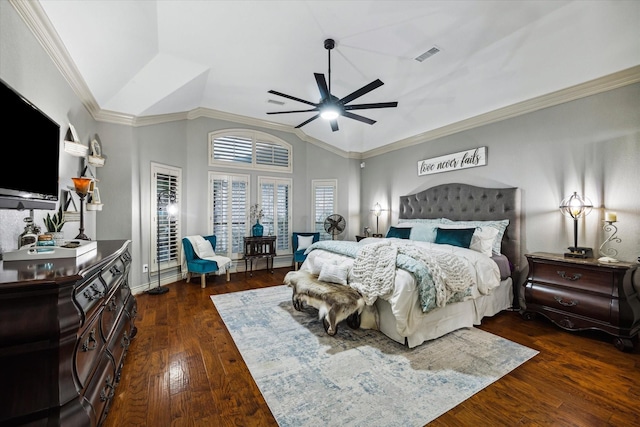 bedroom with vaulted ceiling, wood-type flooring, visible vents, and crown molding