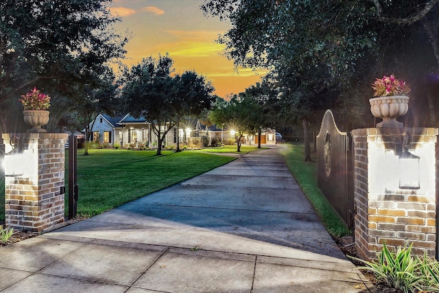 view of road featuring concrete driveway and a gate