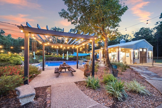 patio terrace at dusk featuring an outdoor pool, fence, and a pergola