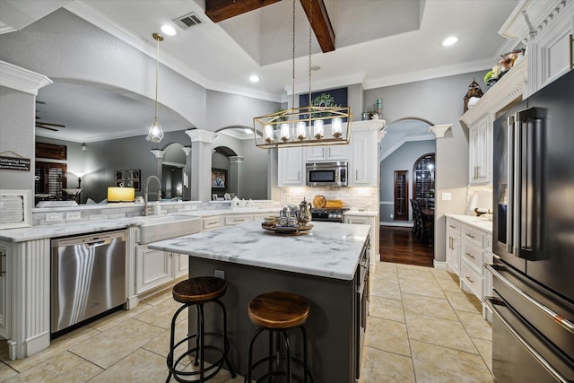 kitchen with visible vents, arched walkways, appliances with stainless steel finishes, ornate columns, and a sink