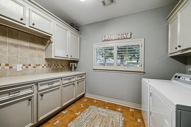 laundry room featuring baseboards, cabinet space, visible vents, and washing machine and clothes dryer