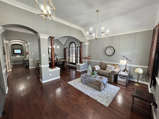 living room with ornate columns, arched walkways, a chandelier, and hardwood / wood-style flooring