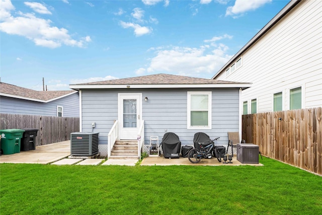 rear view of property featuring a yard, a patio area, and central AC unit