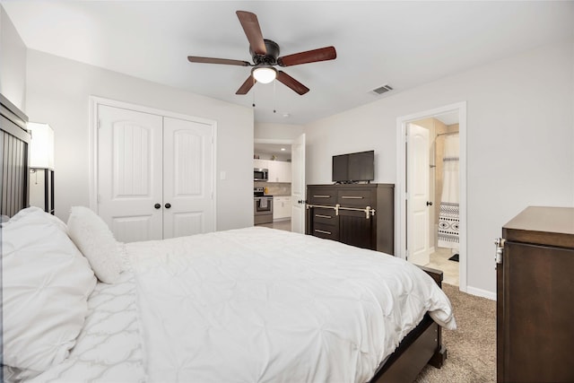 bedroom with ensuite bathroom, a closet, ceiling fan, and carpet flooring