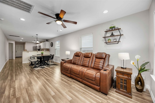 living room with light hardwood / wood-style flooring and ceiling fan