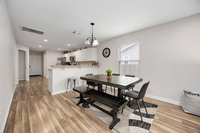 dining room featuring light hardwood / wood-style floors and an inviting chandelier