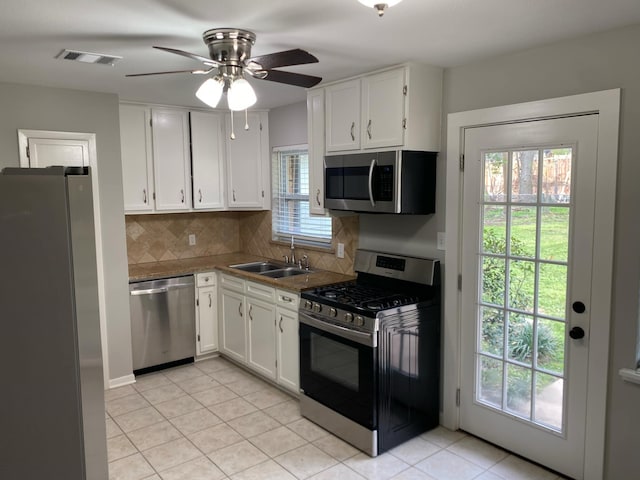 kitchen featuring sink, backsplash, white cabinets, and stainless steel appliances