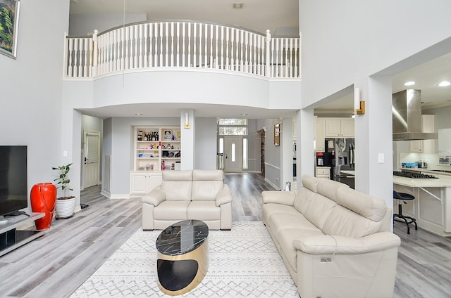 living room with built in features and light hardwood / wood-style flooring