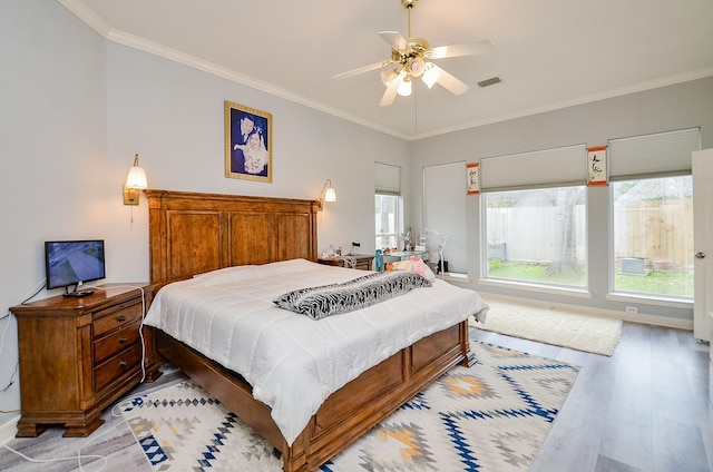 bedroom featuring ceiling fan, ornamental molding, and light hardwood / wood-style flooring