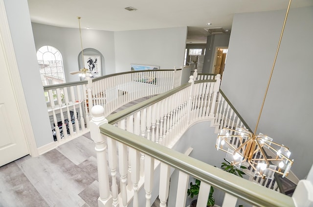 stairs with hardwood / wood-style flooring, ceiling fan, and a high ceiling