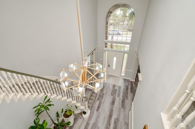 entrance foyer with an inviting chandelier, hardwood / wood-style floors, and a high ceiling