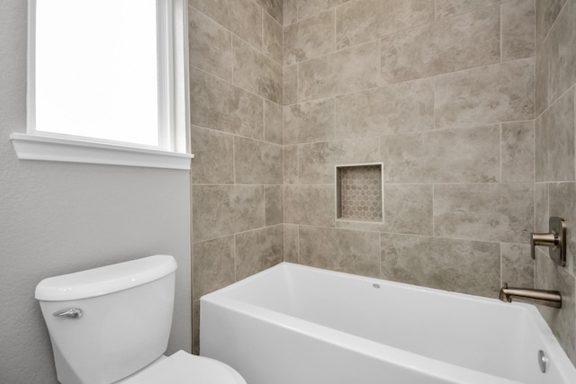 bathroom with toilet and tiled shower / bath combo