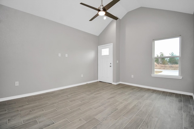 empty room with ceiling fan, high vaulted ceiling, and light hardwood / wood-style floors