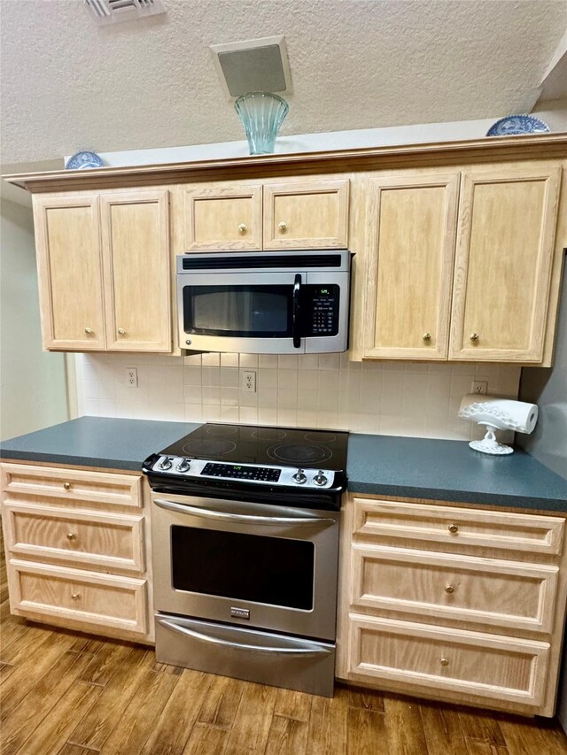 125 Clear Spgs, Trinity, TX 75862 - kitchen with stainless steel appliances, light brown cabinets, dark countertops, dark wood-type flooring, and a textured ceiling