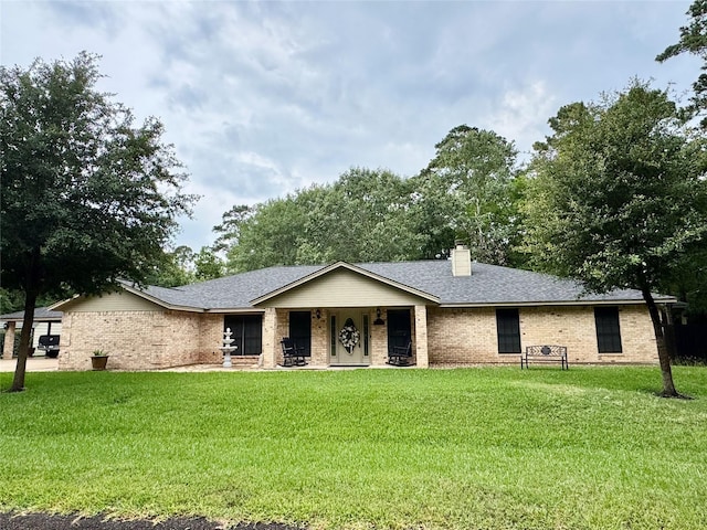 125 Clear Spgs, Trinity, TX 75862 - ranch-style house with a front lawn, brick siding, a chimney, and roof with shingles