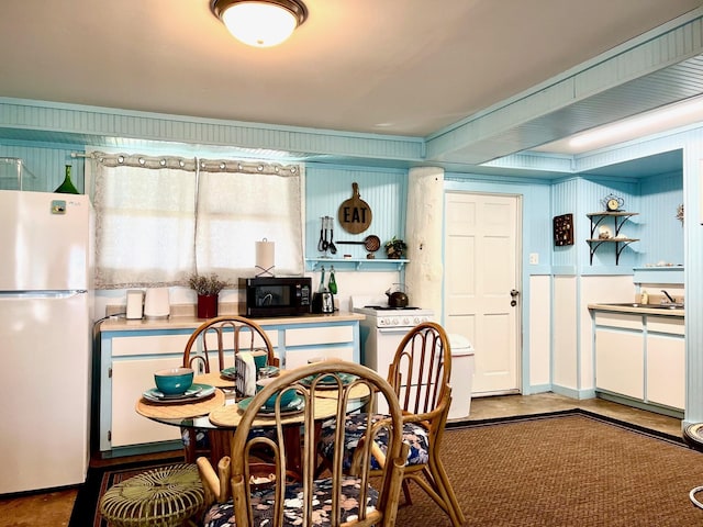 kitchen with white refrigerator and white cabinets