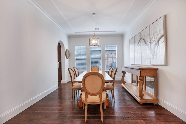 dining space featuring arched walkways, ornamental molding, dark wood finished floors, and baseboards