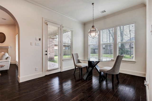 dining room with arched walkways, wood finished floors, visible vents, a wealth of natural light, and crown molding