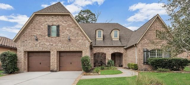 view of front of property with a garage, concrete driveway, and brick siding