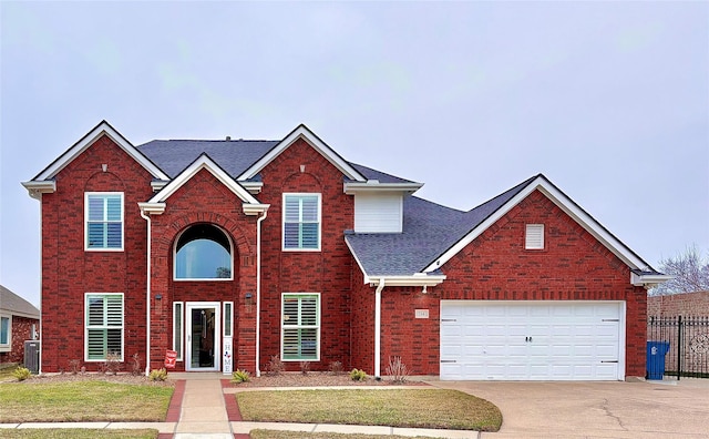 traditional-style home with a garage, brick siding, concrete driveway, central AC, and a front yard