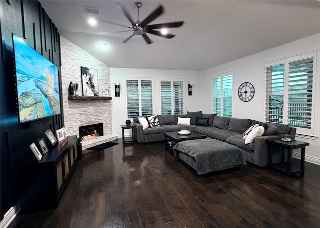 living area featuring a fireplace, visible vents, a ceiling fan, vaulted ceiling, and dark wood finished floors