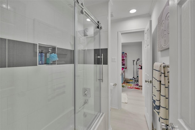 bathroom with ornamental molding and combined bath / shower with glass door