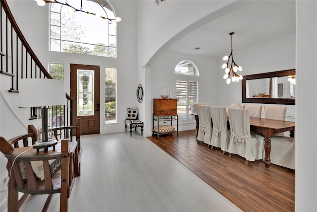 entryway with dark wood-type flooring, a chandelier, and a high ceiling