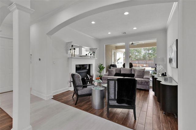 living room featuring hardwood / wood-style flooring, ornamental molding, and ceiling fan