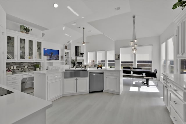 kitchen featuring tasteful backsplash, dishwasher, sink, white cabinets, and hanging light fixtures