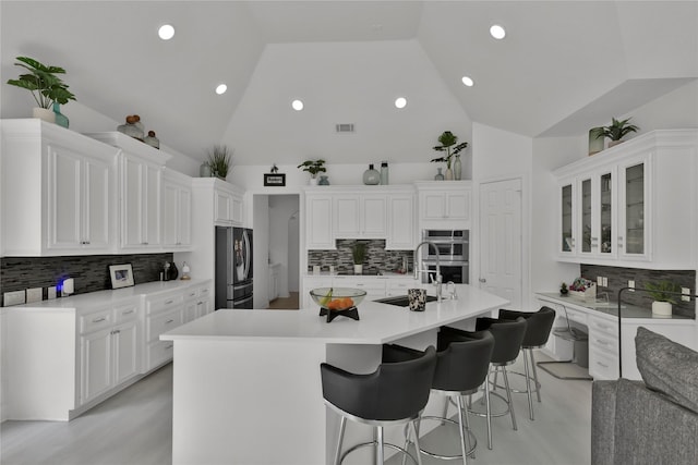 kitchen with appliances with stainless steel finishes, sink, an island with sink, and white cabinets