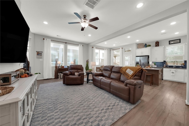 living area with ceiling fan, visible vents, wood finished floors, and recessed lighting