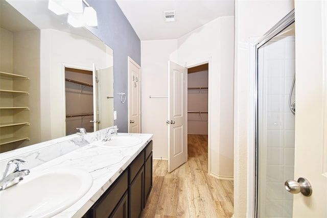 bathroom with hardwood / wood-style flooring, vanity, and an enclosed shower