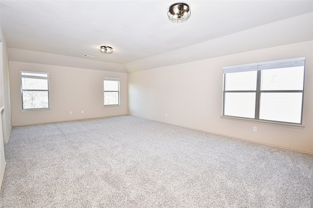 spare room featuring lofted ceiling and carpet flooring