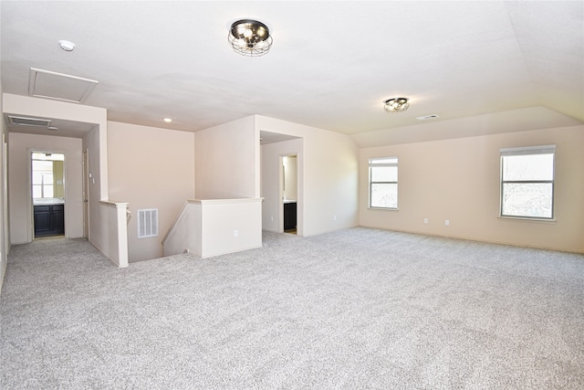 unfurnished room featuring vaulted ceiling and light carpet