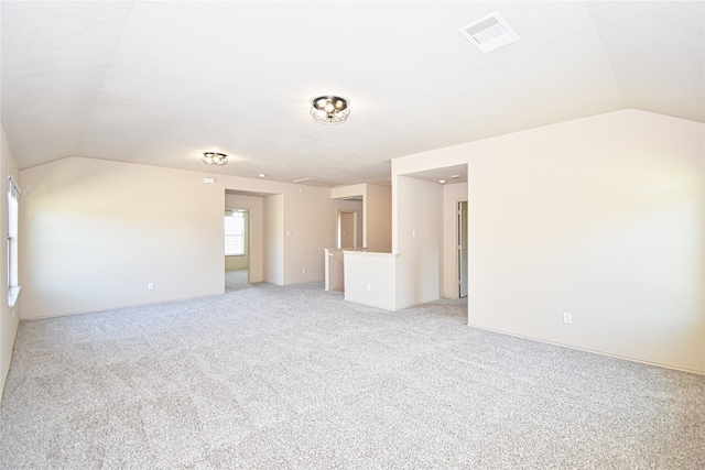 spare room with light colored carpet and lofted ceiling