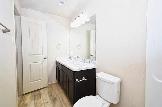 bathroom featuring vanity, hardwood / wood-style floors, and toilet