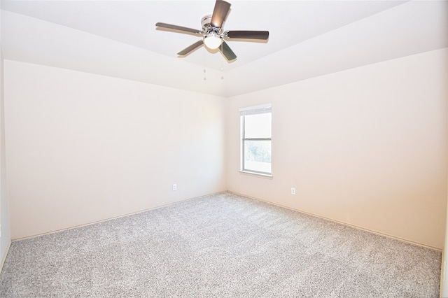 carpeted empty room featuring ceiling fan and a tray ceiling