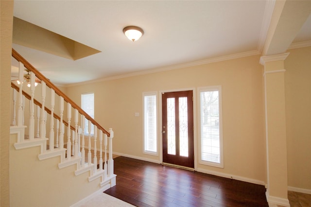 entryway with decorative columns, ornamental molding, and dark hardwood / wood-style floors