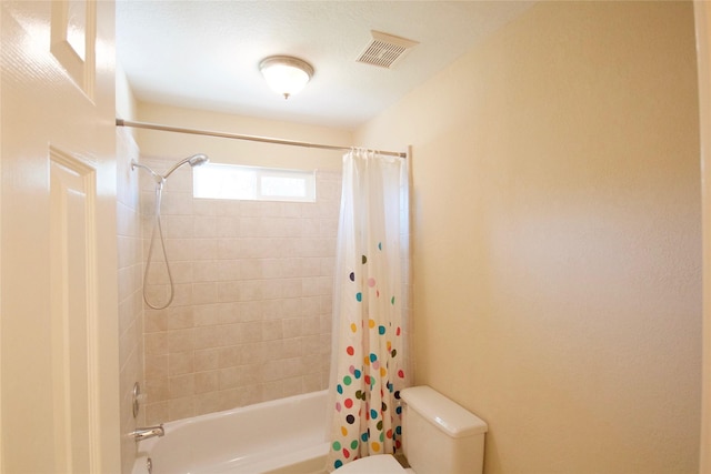 bathroom featuring shower / bathtub combination with curtain and toilet