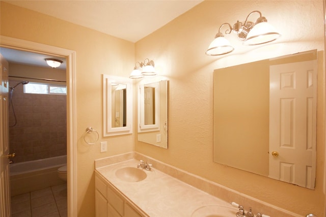 full bathroom with tile patterned flooring, vanity, tiled shower / bath, and toilet