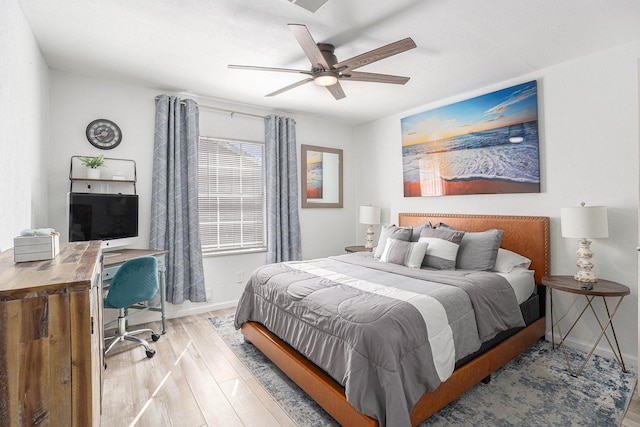 bedroom with light wood finished floors, ceiling fan, visible vents, and baseboards