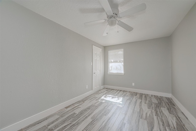 empty room with ceiling fan, light hardwood / wood-style floors, and a textured ceiling