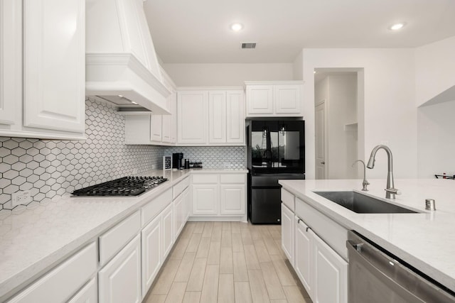 kitchen featuring appliances with stainless steel finishes, sink, custom exhaust hood, and white cabinets