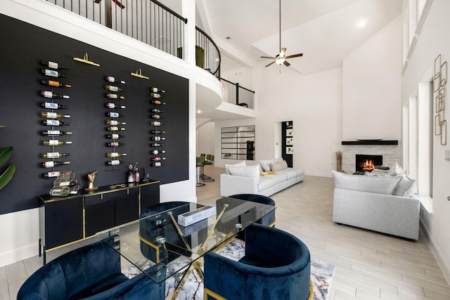 wine room featuring ceiling fan, a towering ceiling, and light hardwood / wood-style floors