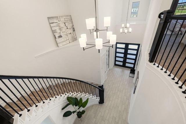 foyer entrance with plenty of natural light, a chandelier, and light hardwood / wood-style flooring