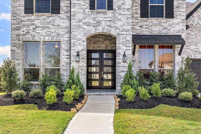 entrance to property with a lawn and french doors